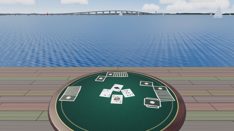 A spades hand dealt on a green card table on a bayside deck